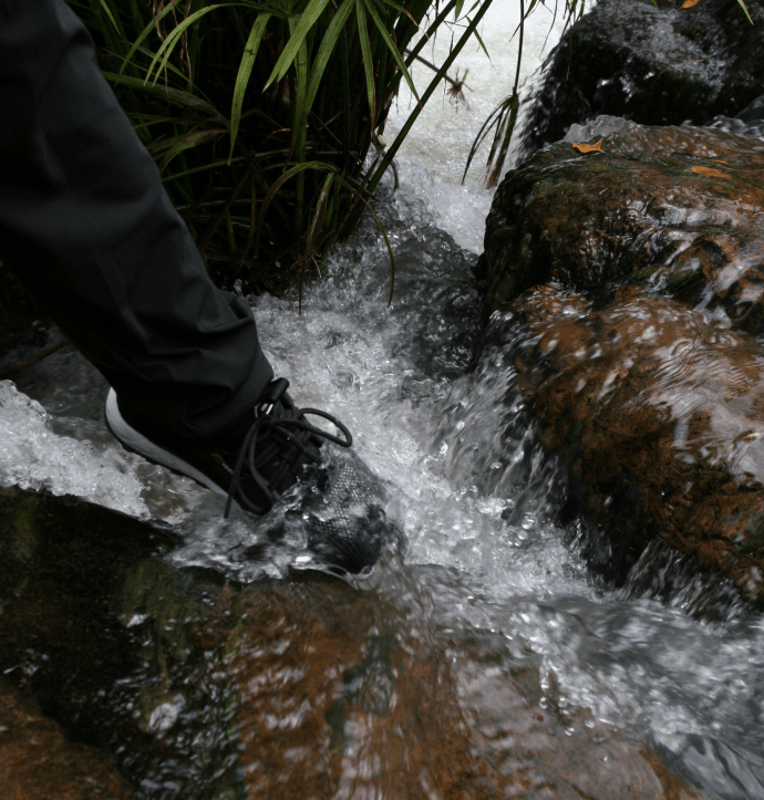 Black shoes moving through splashing water