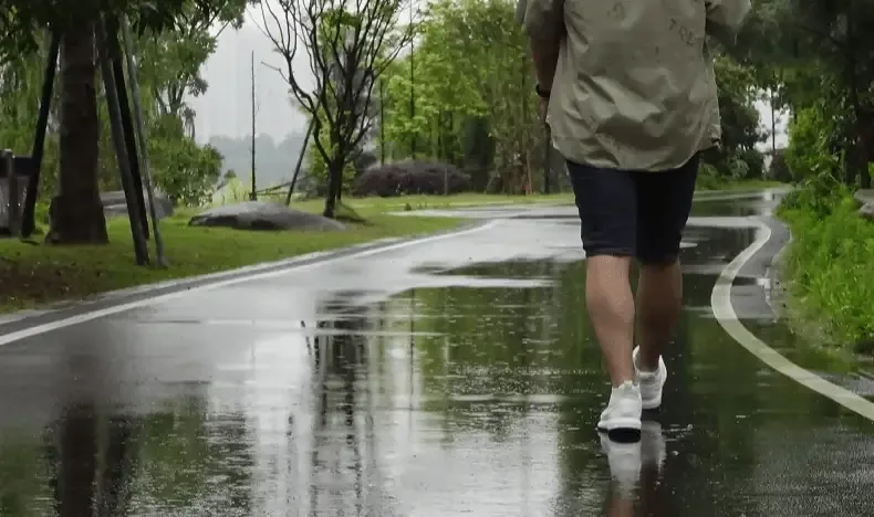 Walking outside in white sneakers along wet pavement